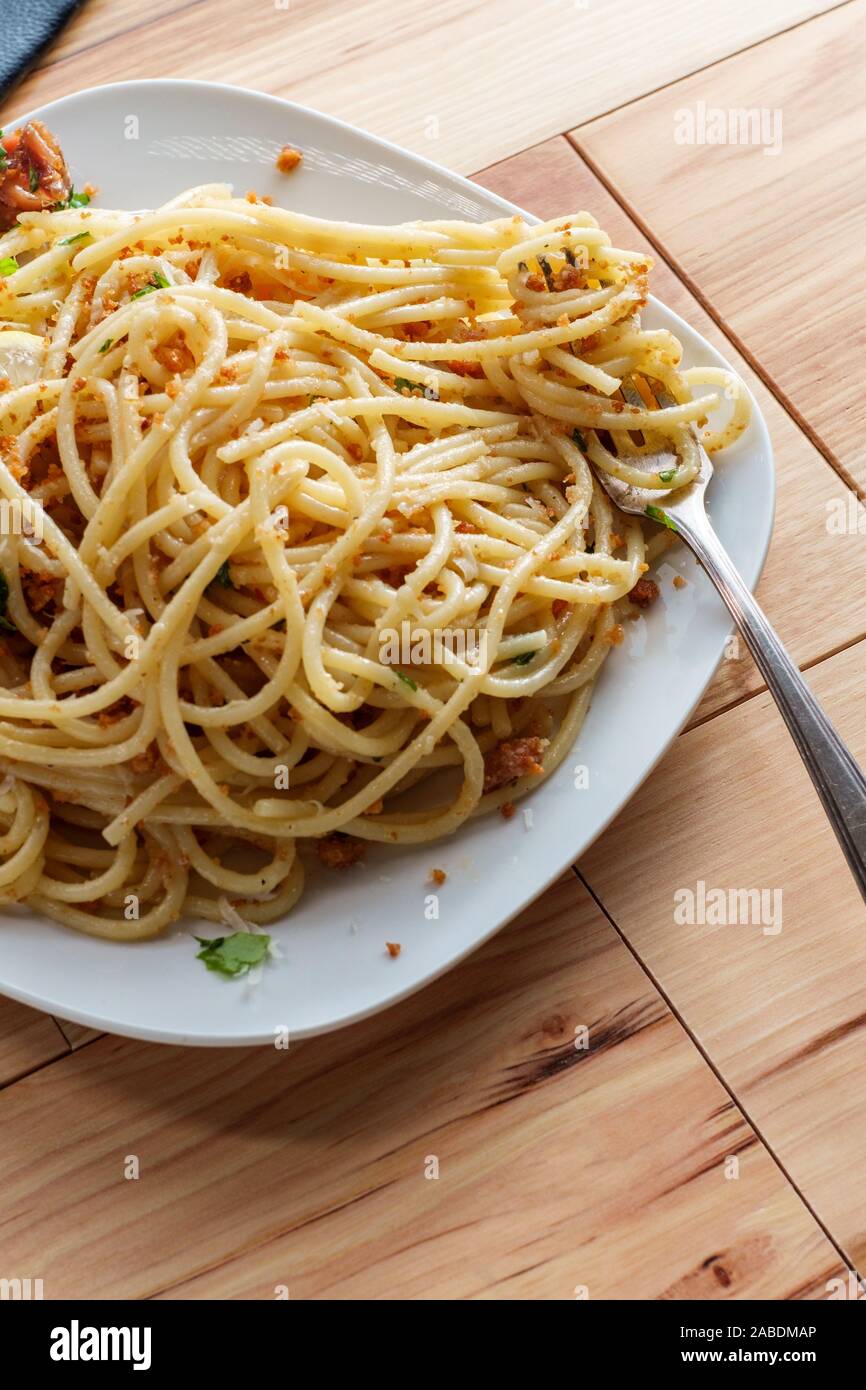 Italian spaghetti mollicata con pangrattato parmigiano reggiano in un acciuga salsa al vino bianco Foto Stock