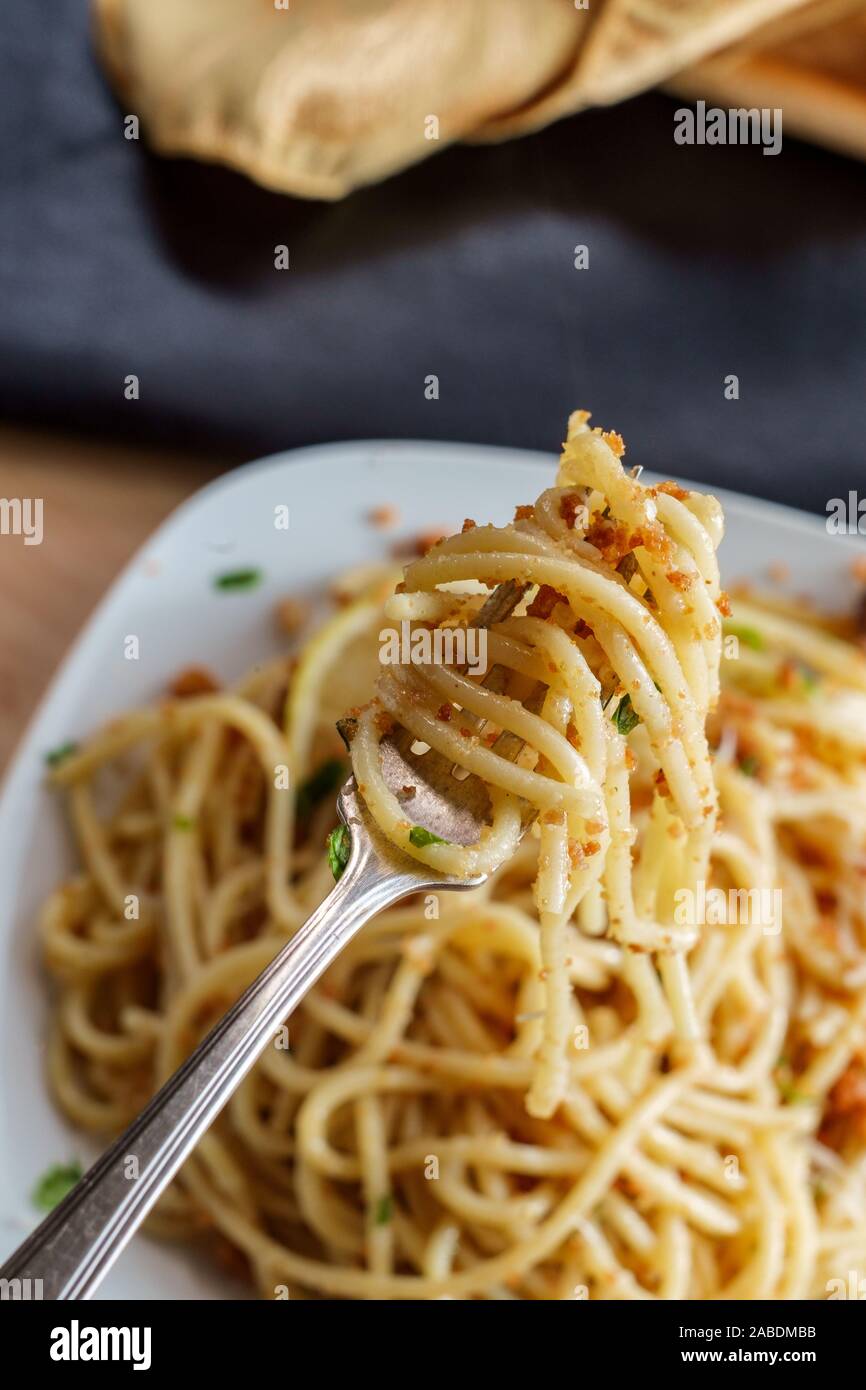 Italian spaghetti mollicata con pangrattato parmigiano reggiano in un acciuga salsa al vino bianco Foto Stock