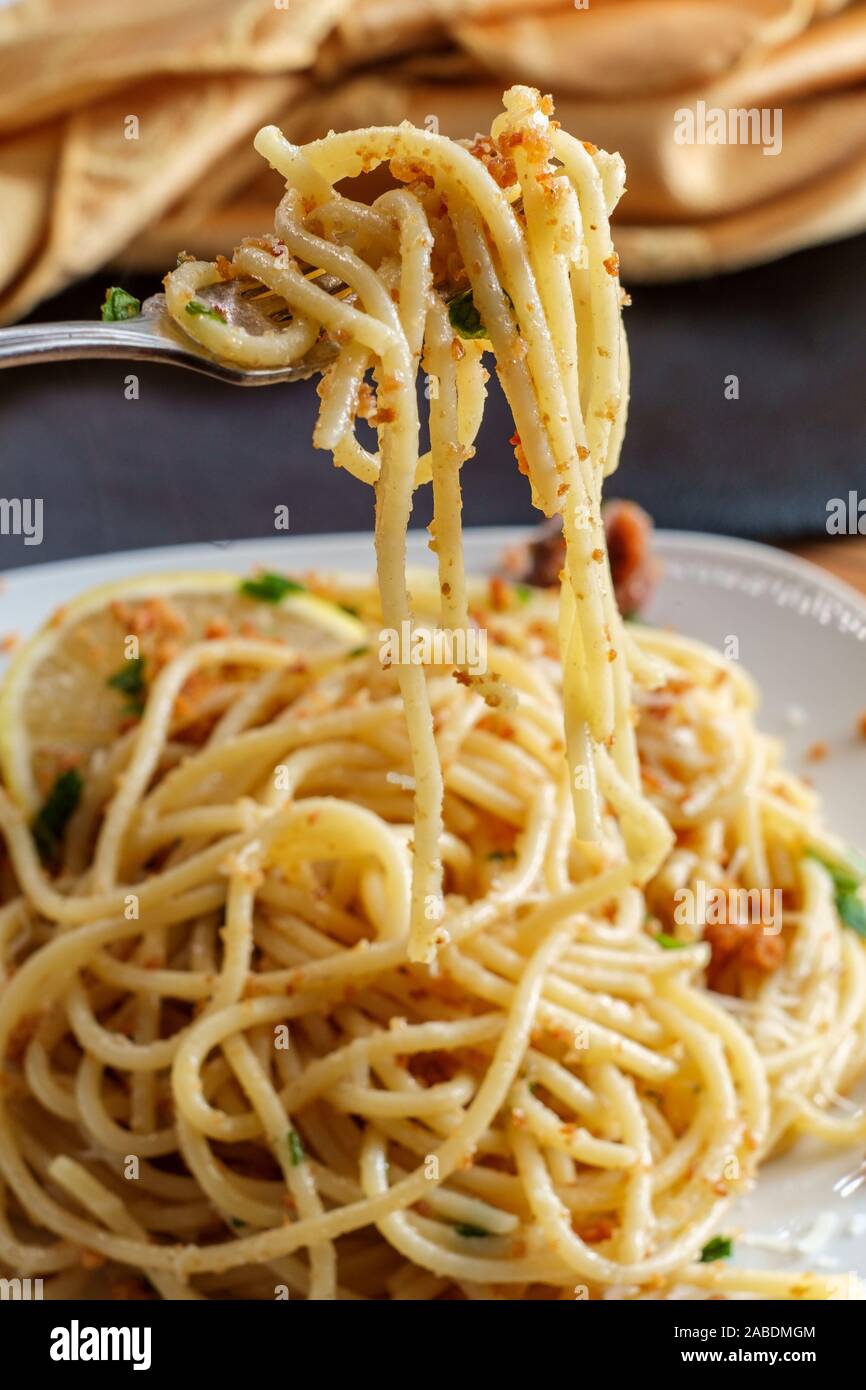 Italian spaghetti mollicata con pangrattato parmigiano reggiano in un acciuga salsa al vino bianco Foto Stock