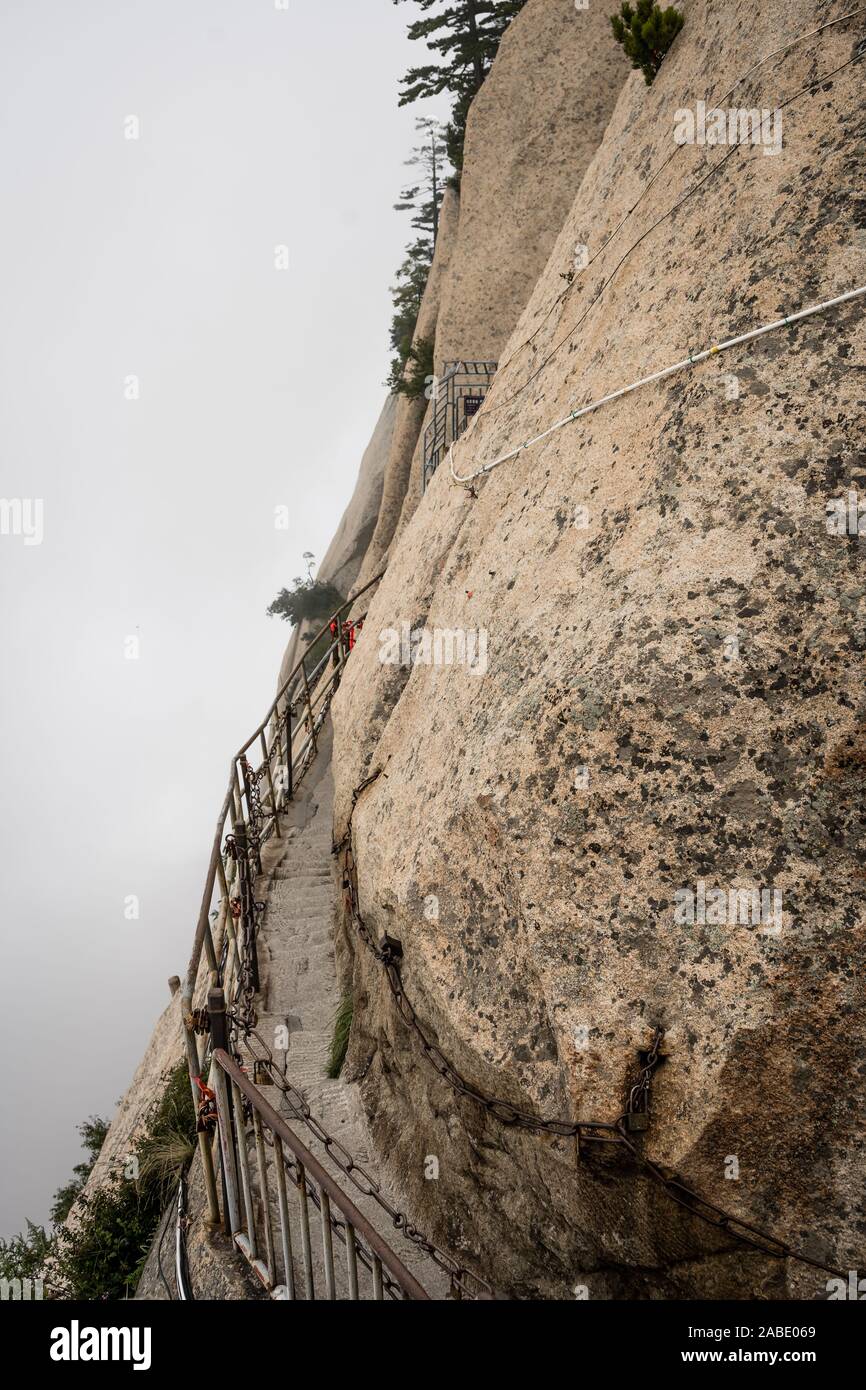 Scale in pietra di taglio su un lato di una roccia di montagna che conduce alla pericolosa e pericolosa Plank a piedi il sentiero, chiuso per l'accesso del pubblico a causa di cattive condizioni metereologiche condi Foto Stock