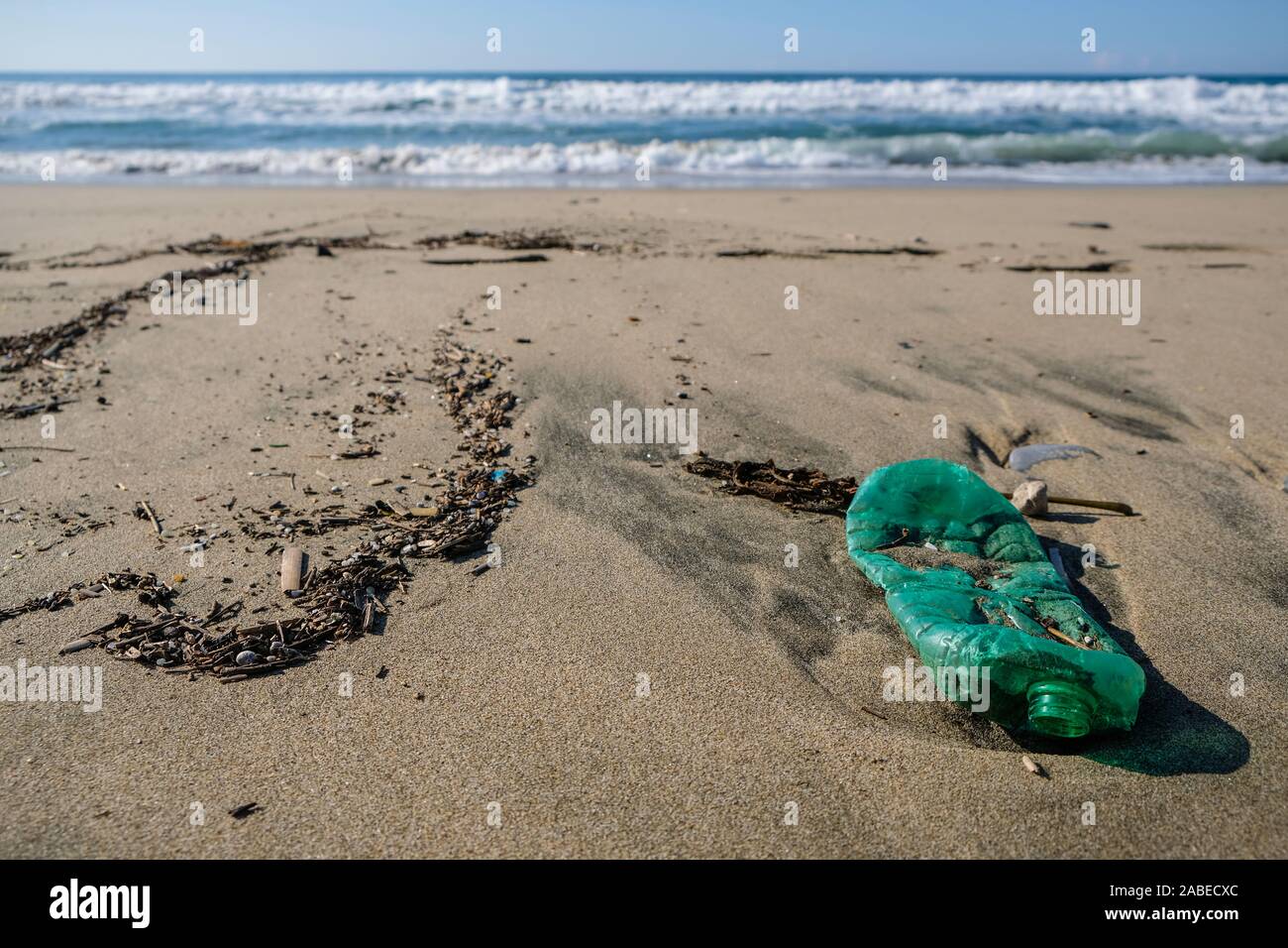 Verde bottiglia di plastica sulla costa del mare, ecosistema inquinamento pianeta salvare concetto, 4k Foto Stock
