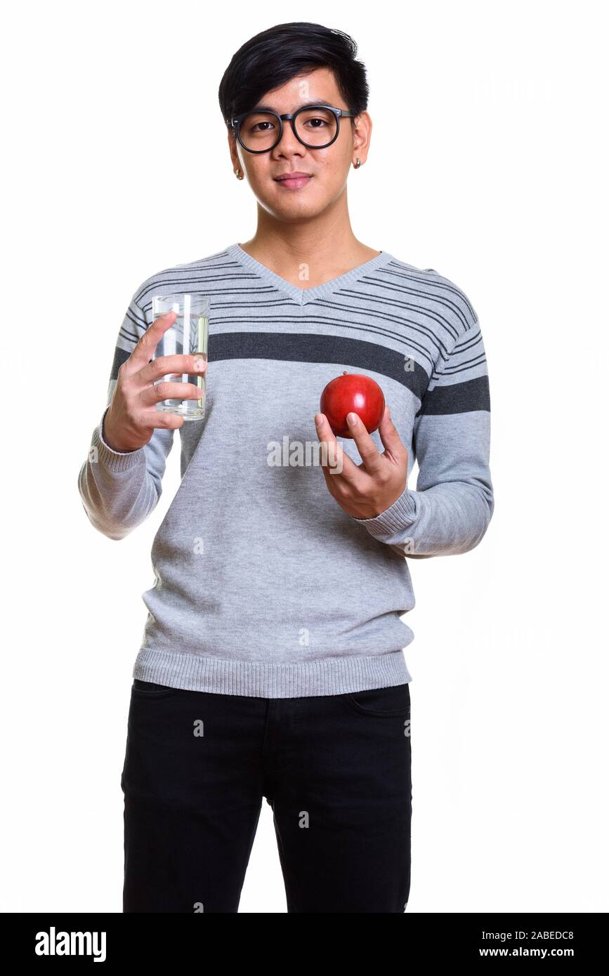 Studio shot di bello uomo asiatico tenendo un bicchiere di acqua e rosso Foto Stock