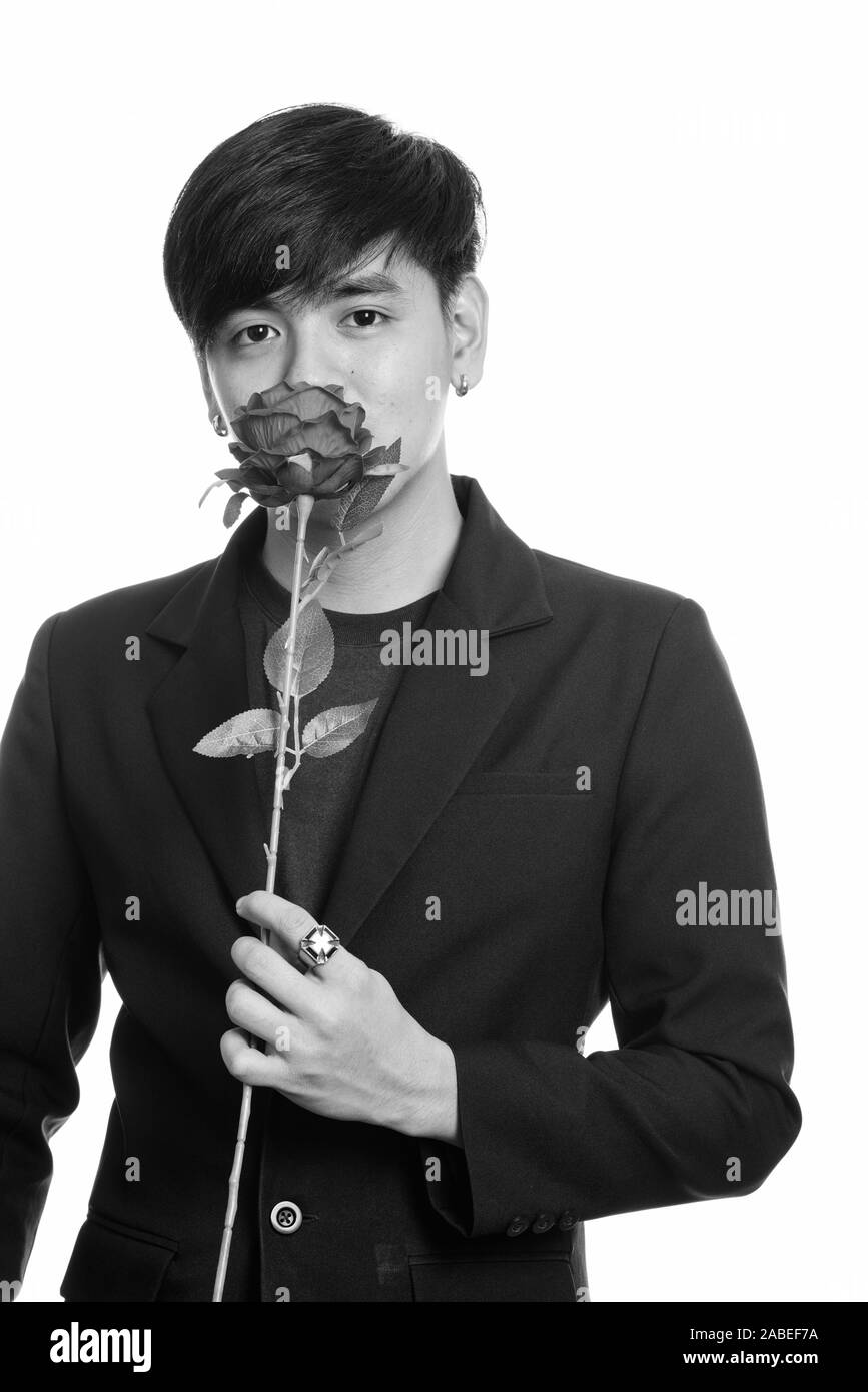 Studio shot di cool bello imprenditore asiatici odore di rose rosse Foto Stock