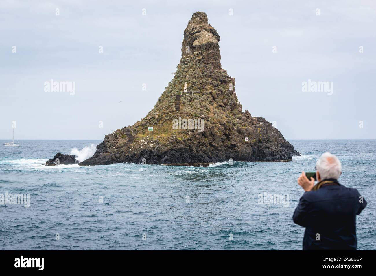 Isolotto con Madonna figura - una delle isole ciclopiche di Aci Trezza comune, una frazione di Aci Castello comune vicino a Catania sull isola di Sicilia in Italia Foto Stock