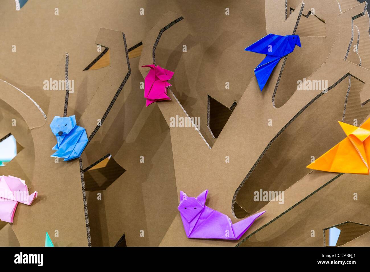 Animali colorati origami sui rami di albero di carta Foto Stock