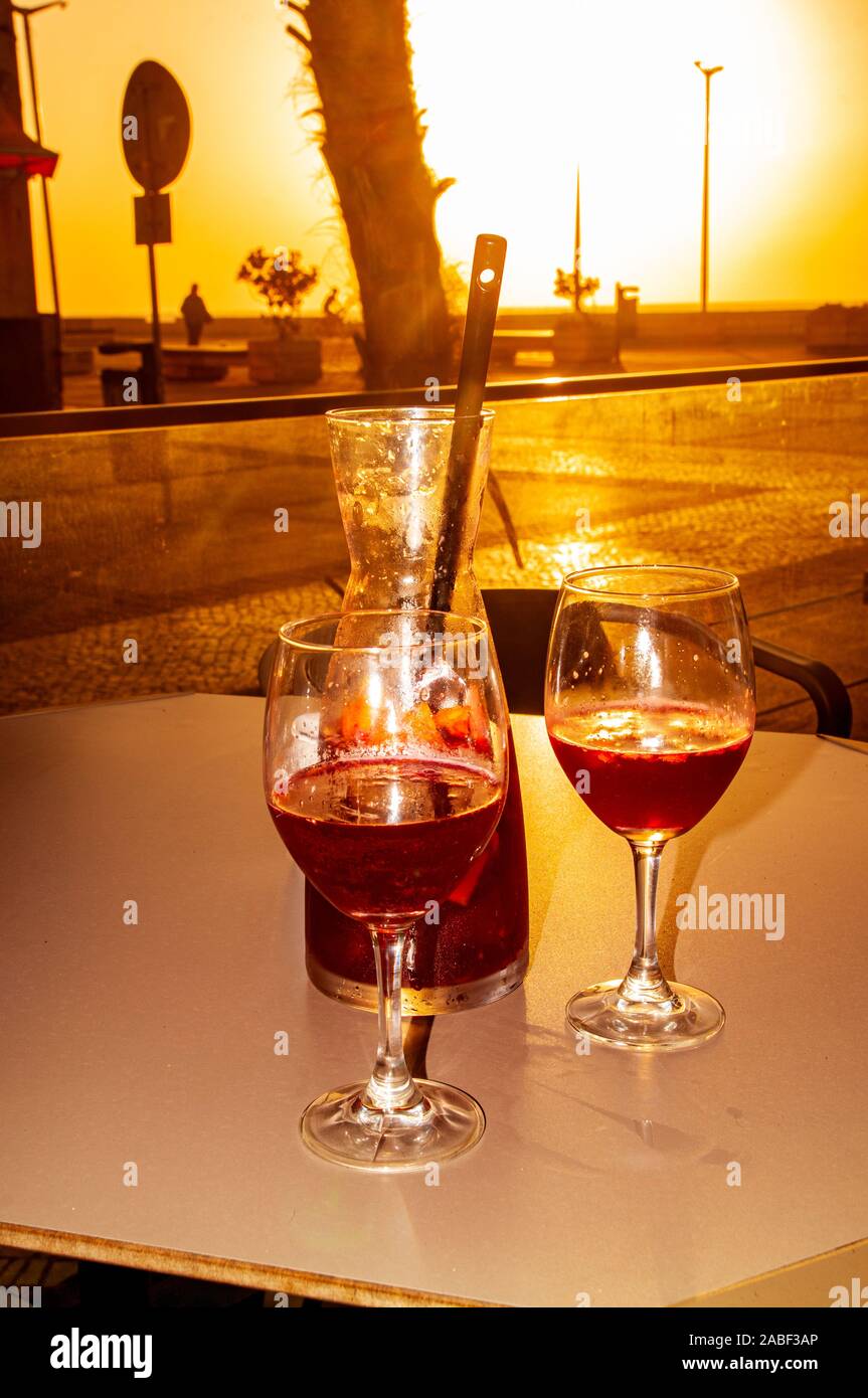 Concetto di vacanza due bicchieri di sangria e una brocca sulla costa atlantica al tramonto Foto Stock