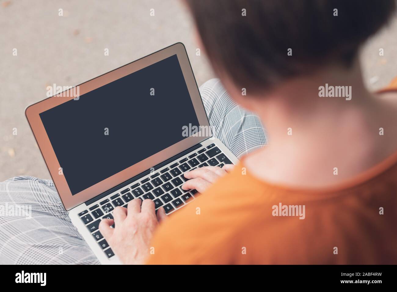 Donna che utilizza computer portatili sul banco di strada, mock up schermo di messa a fuoco selettiva immagine Foto Stock