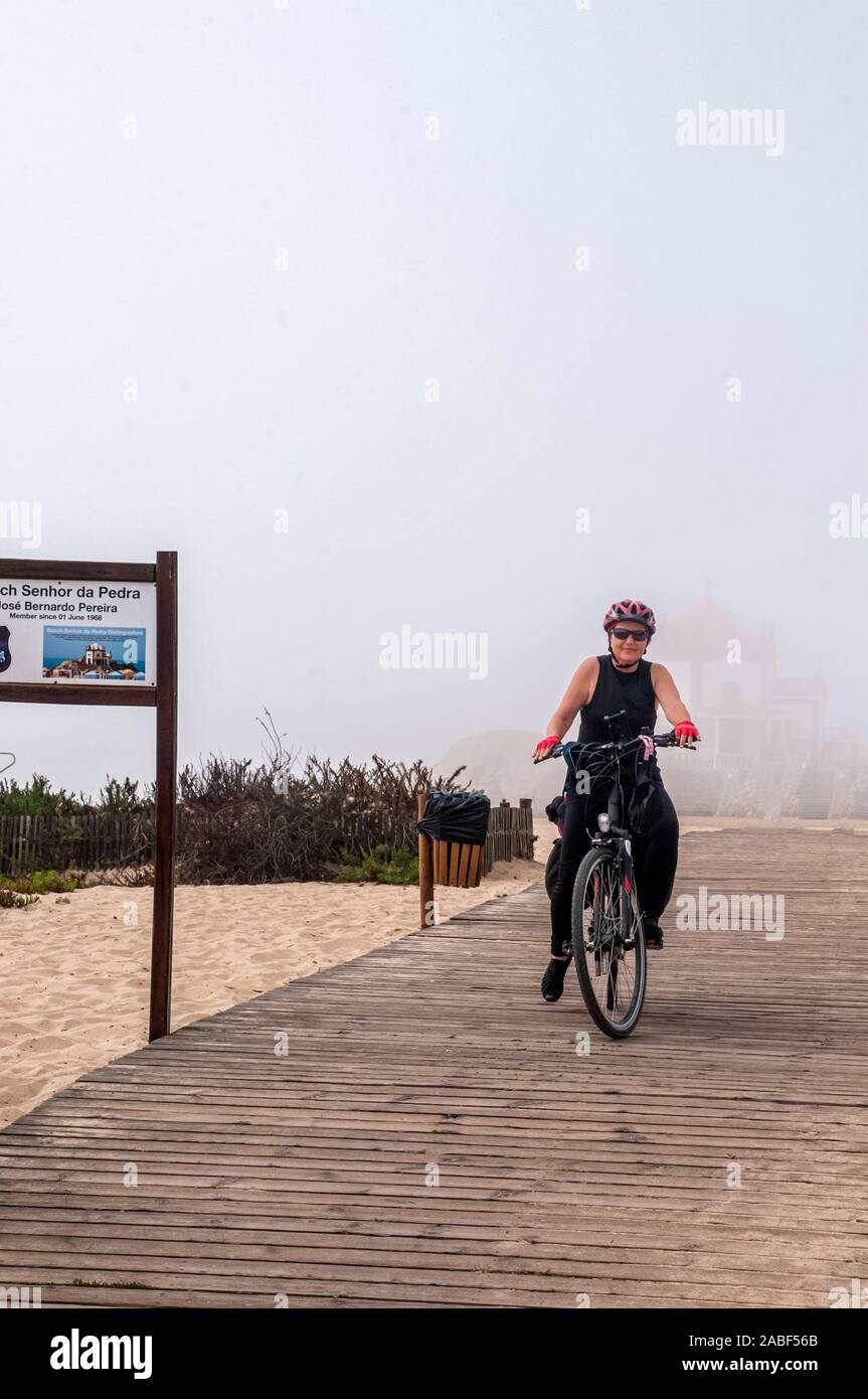 Cicli di donna sulla Eurovelo 1 costa atlantica rotta vicino Porto, Portogallo. Costa dell'Oceano Atlantico sulla sinistra Foto Stock