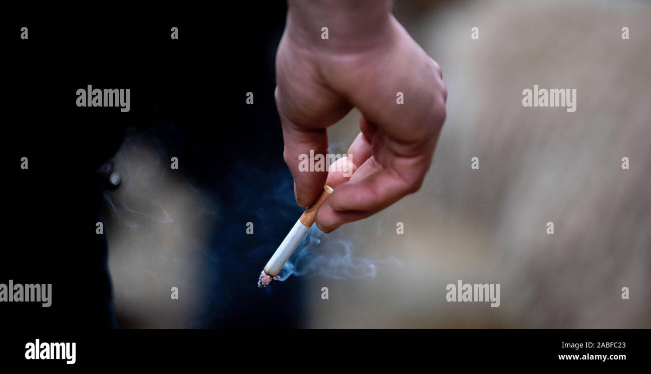 Persona in possesso di una sigaretta accesa. Yorkshire, Regno Unito. Foto Stock