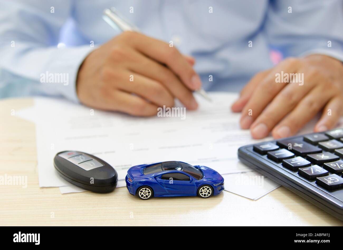 Giocattolo auto finance calculator, chiavi auto e documenti sulla scrivania.auto di assicurazione nozione Foto Stock