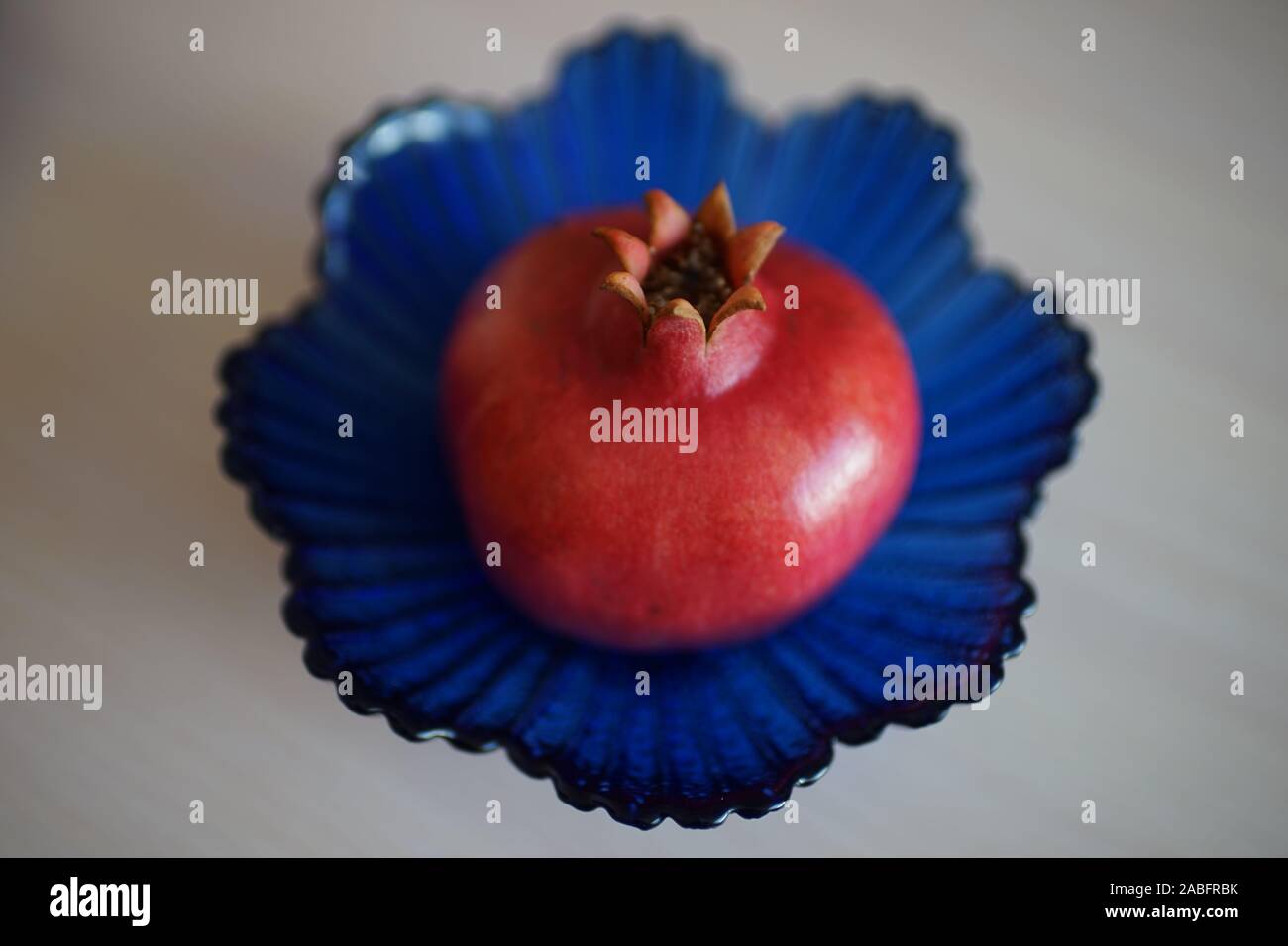 Tutto mature melagrana sul cristallo blu vaso. Foto Stock