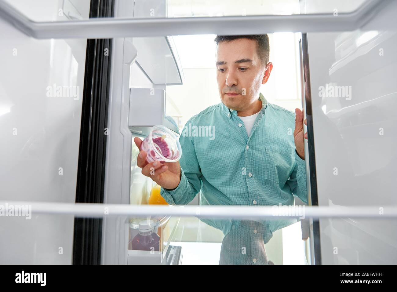 L'uomo prendendo vuoto contenitore di cibo dal frigo Foto Stock