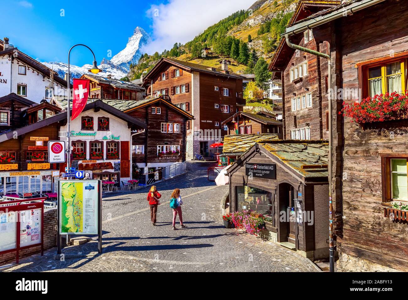 Zermatt, Svizzera - Ottobre 7, 2019: Town street view nel famoso swiss ski resort, Cervino Snow mount, case tradizionali e persone Foto Stock