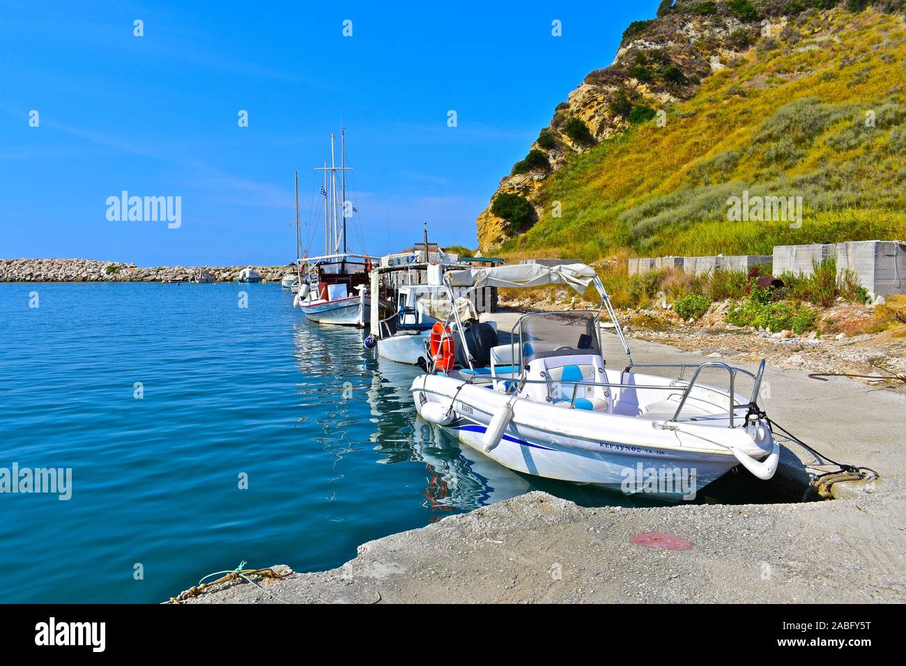 Imbarcazioni da diporto e imbarcazioni da pesca ormeggiate nel porto del bellissimo villaggio di pescatori di Katelios con lo spettacolare sfondo delle montagne. Foto Stock