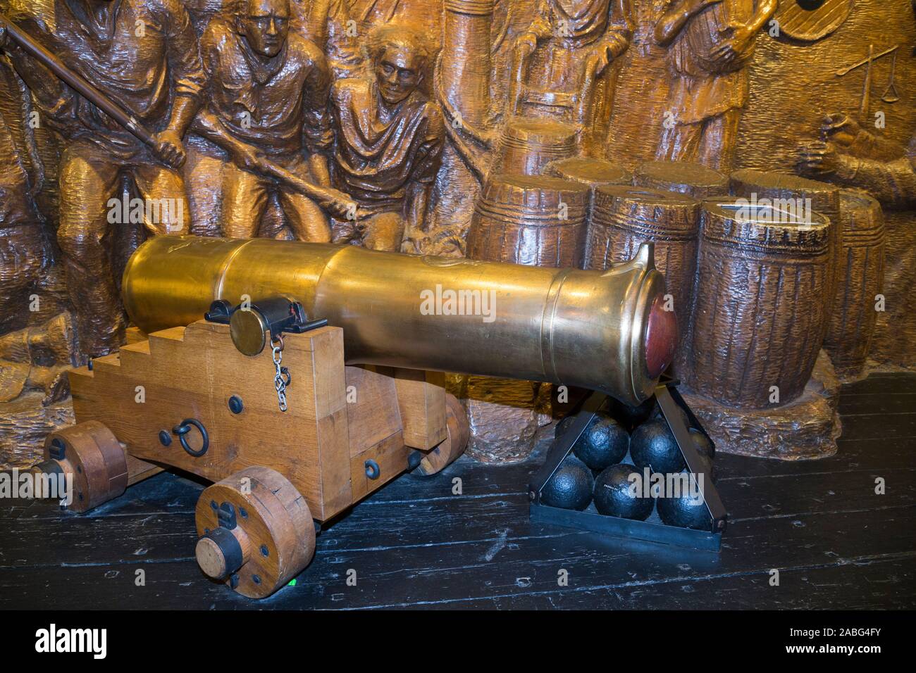 Display della pistola di un inizio di Canon e palle di cannone nella parte anteriore di un tableau di battaglia presso il Museo di esplosione della potenza di fuoco navale; la Royal Navy dell ex deposito degli armamenti di Priddy's Hard, a Gosport. Regno Unito (105) Foto Stock