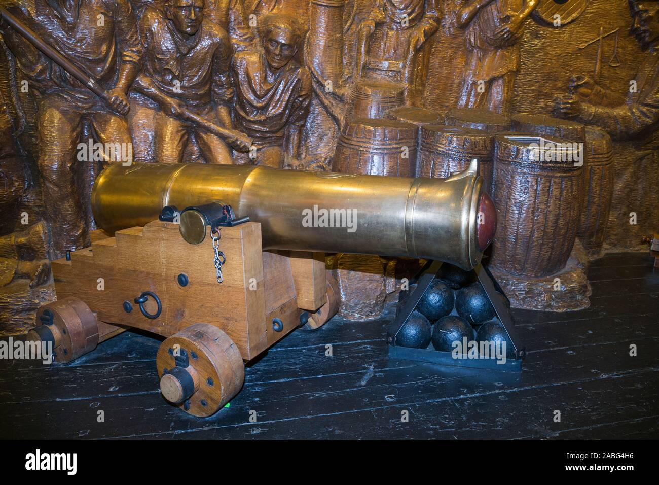 Display della pistola di un inizio di Canon e palle di cannone nella parte anteriore di un tableau di battaglia presso il Museo di esplosione della potenza di fuoco navale; la Royal Navy dell ex deposito degli armamenti di Priddy's Hard, a Gosport. Regno Unito (105) Foto Stock