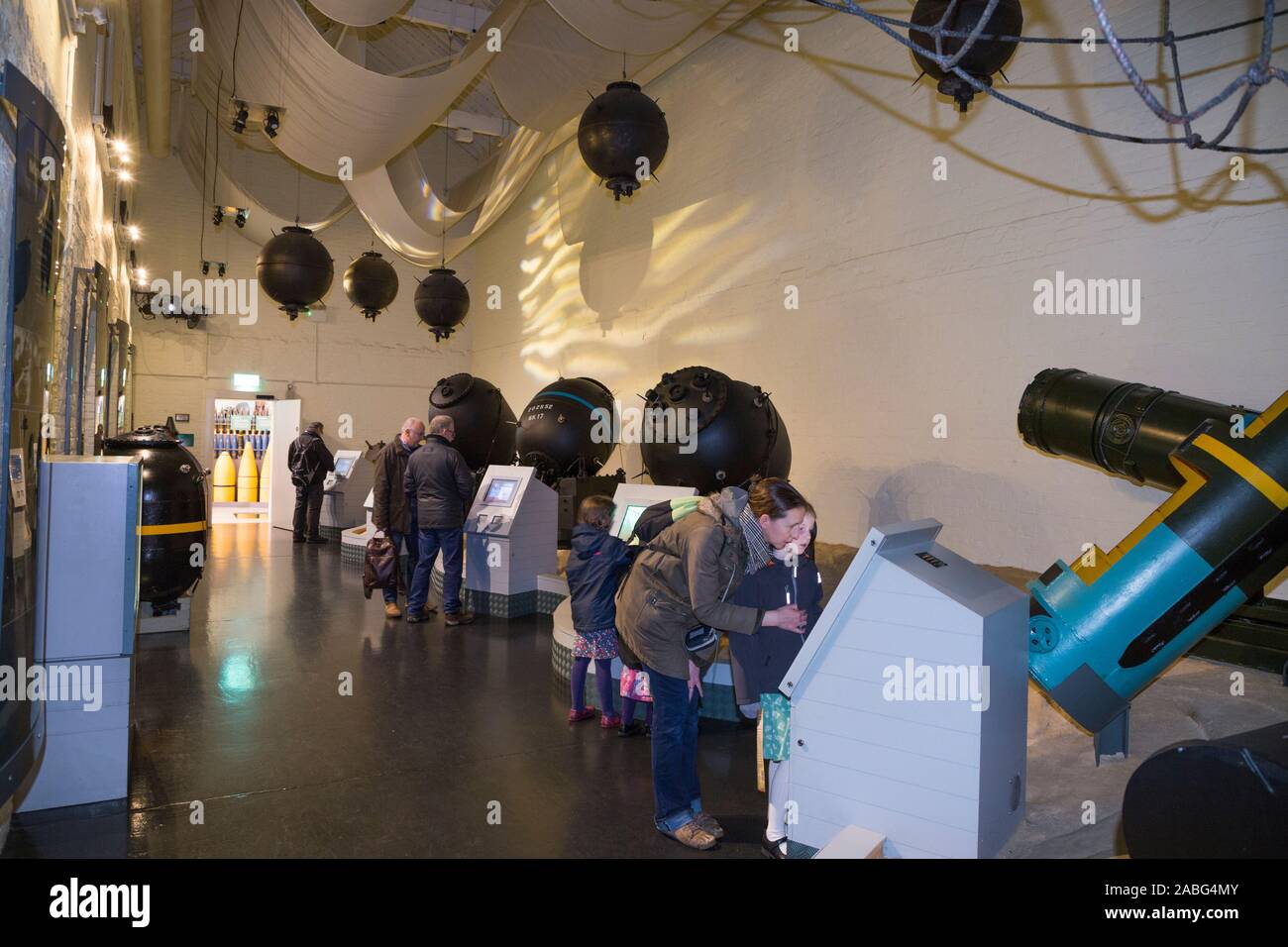 I turisti guardano il mare esplosiva mine / mine sul display all'interno del museo di esplosione della potenza di fuoco navale; la Royal Navy dell ex deposito degli armamenti di Priddy's Hard, a Gosport. Regno Unito (105) Foto Stock