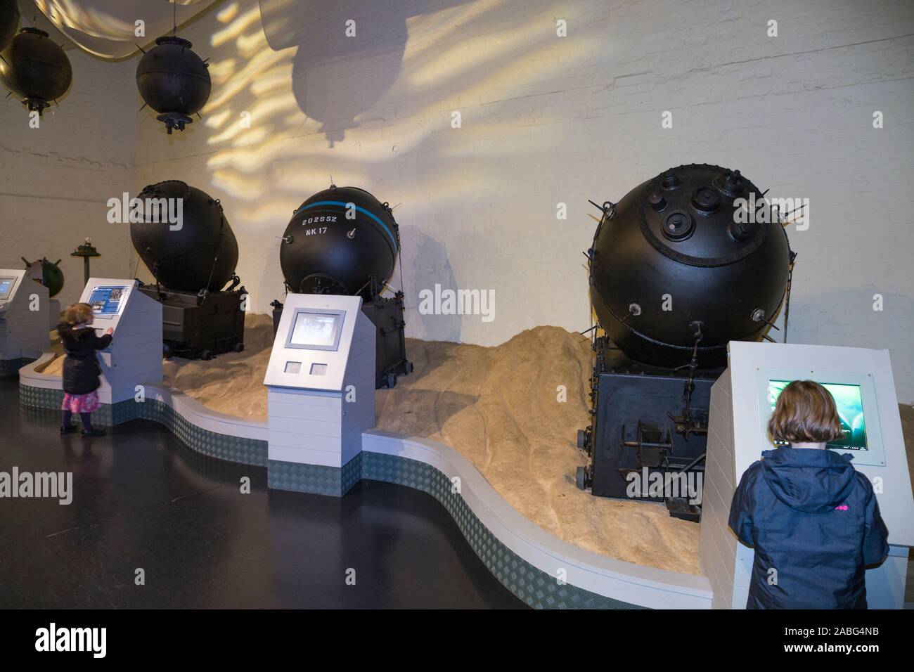 I turisti guardano al mare esplosiva mine / mine sul display all'interno del museo di esplosione della potenza di fuoco navale; la Royal Navy dell ex deposito degli armamenti di Priddy's Hard, a Gosport. Regno Unito (105) Foto Stock