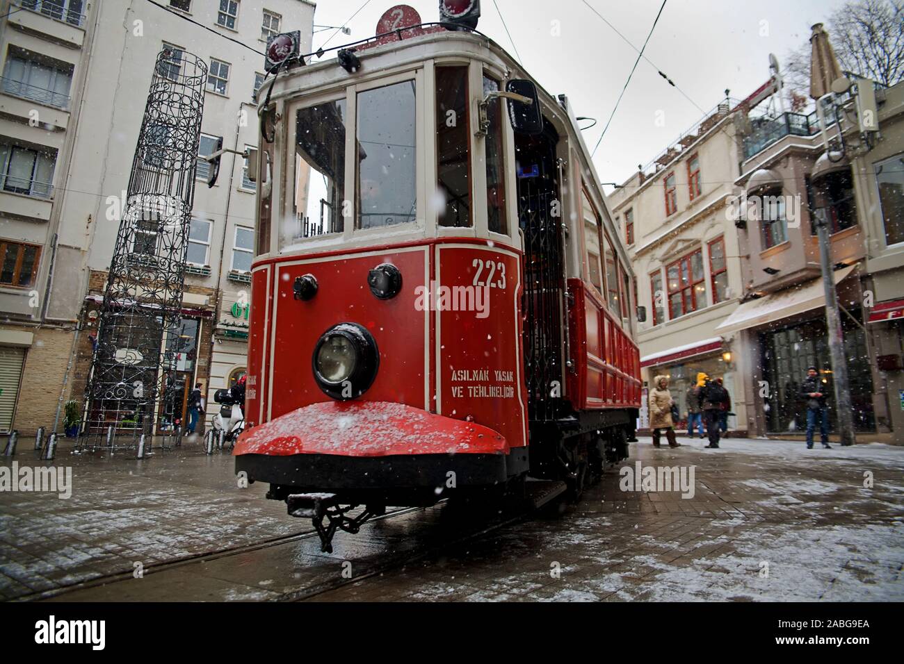 Istanbul, Turchia - 31 Gennaio 2012: un tram nostalgico passando dalla Istiklal Street quando nevicate a Istanbul,Taksim, alcuni popoli a piedi. Foto Stock
