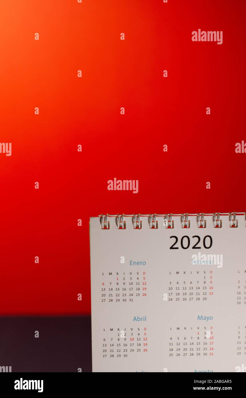 Anno Nuovo 2020 Calendario sulla scrivania, rosso sfondo illuminato. Pianificazione, organizzazione del nuovo anno, mesi dell'anno nuovo. Vista anteriore dell'oggetto con e Foto Stock