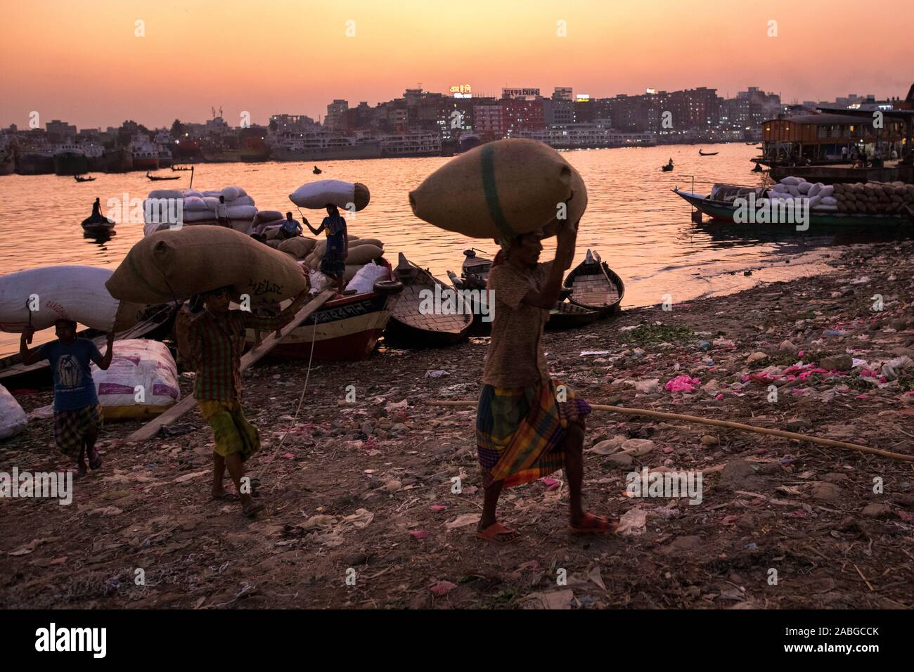 Dacca in Bangladesh - Novembre 27, 2019 : Operaio lo scarico di merci da barca nel fiume Burigana. Foto Stock