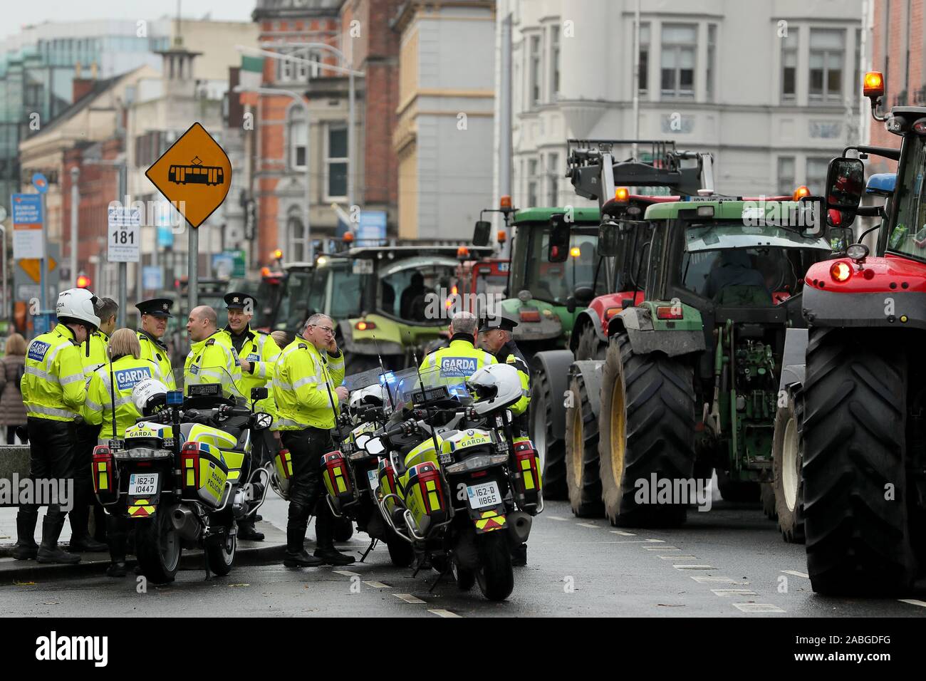 I membri di un garda a fianco di trattori parcheggiati nelle strade intorno a Santo Stefano verde nel centro della città di Dublino come una manifestazione di protesta da parte degli agricoltori al di sopra dei prezzi da ottenere per i loro prodotti continua. Foto Stock