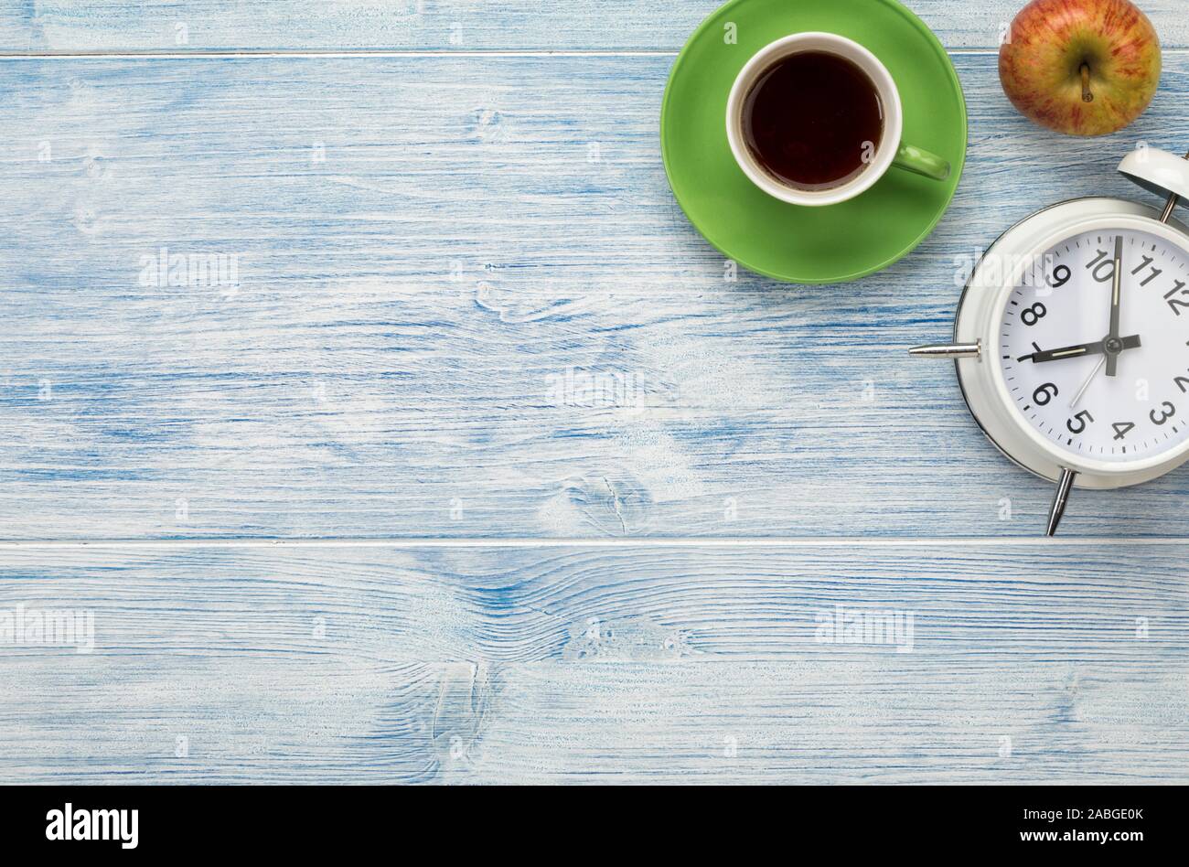 Sveglia, tazza di caffè e apple sullo sfondo di legno con copia spazio. Pausa caffè concetto. Foto Stock