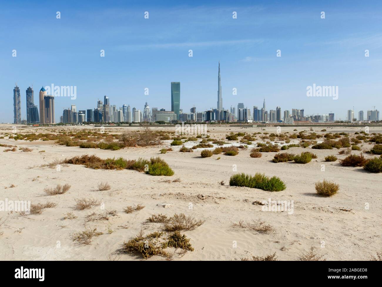 Skyline di Dubai con il Burj Khalifa Tower prominente e deserto in primo piano negli Emirati Arabi Uniti , EMIRATI ARABI UNITI Foto Stock