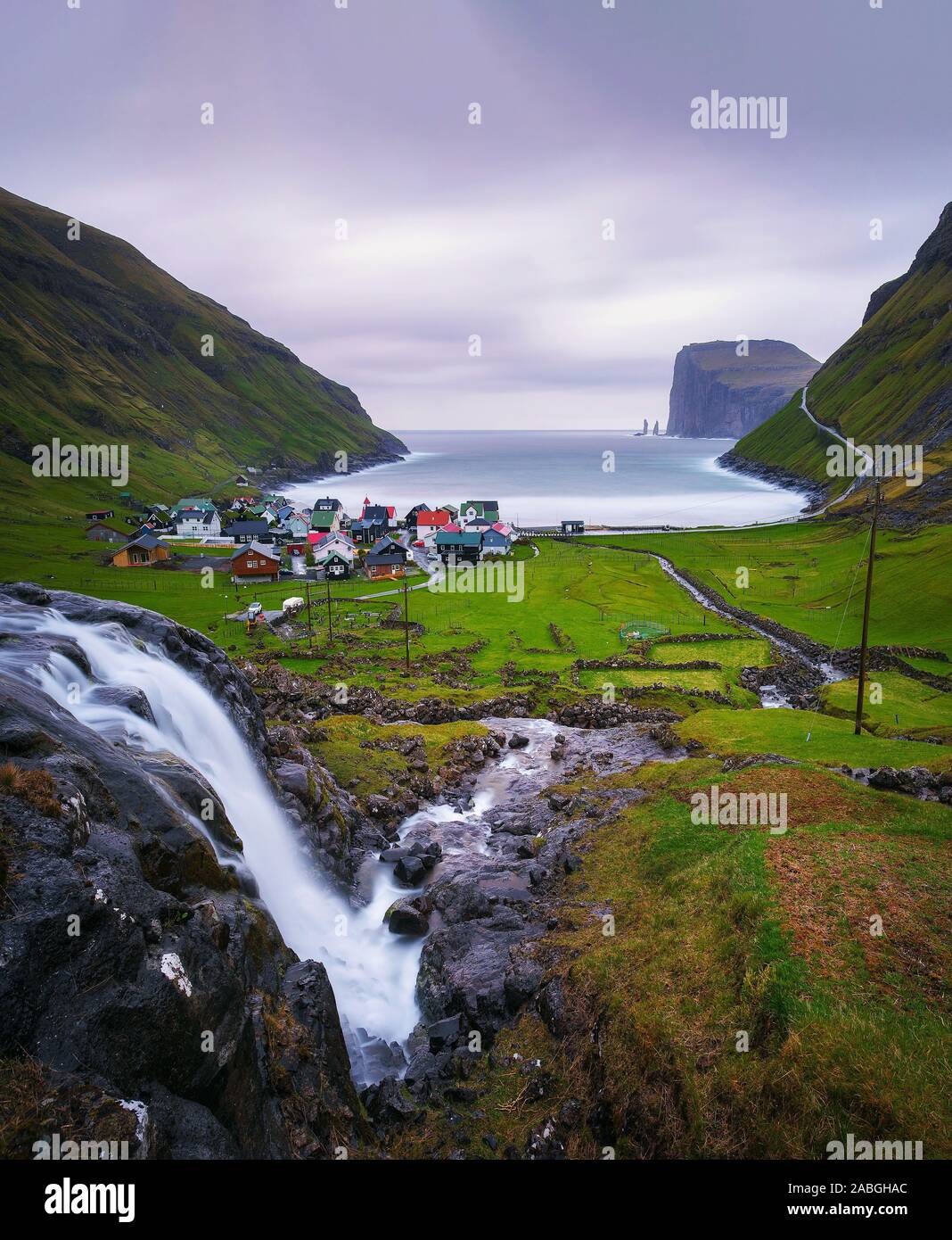 La cascata e il villaggio di Tjornuvik nelle isole Faerøer Foto Stock