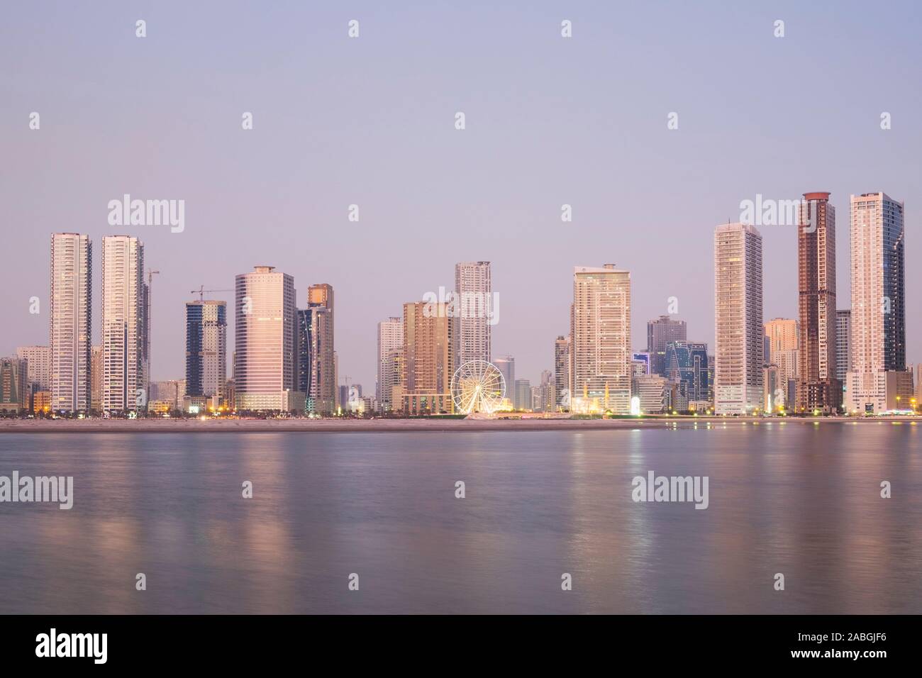 Crepuscolo vista dello skyline di spiaggia e alto e moderno appartamento edifici lungo la corniche in Sharjah Emirati Arabi Uniti Foto Stock Crepuscolo vista dello skyline di spiaggia e alto e moderno appartamento edifici lungo la corniche in Sharjah Emirati Arabi Uniti Foto Stock