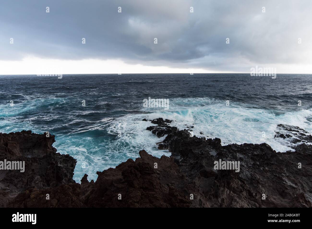 Mare tempestoso su nero costa vulcanica Foto Stock