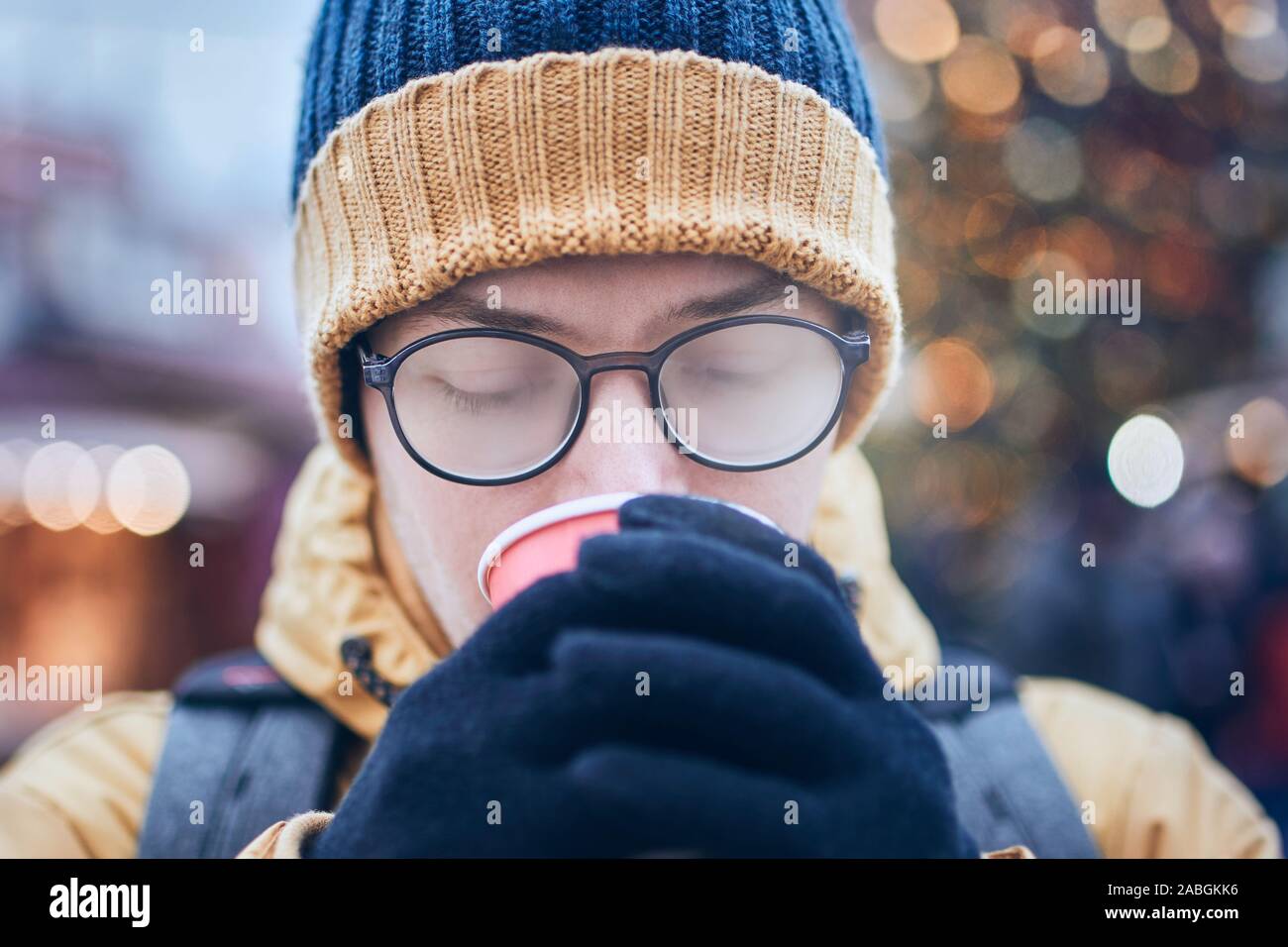Giovane con foggy fino occhiali di bere vino caldo. Mercatino di Natale a Tallinn in Estonia. Foto Stock