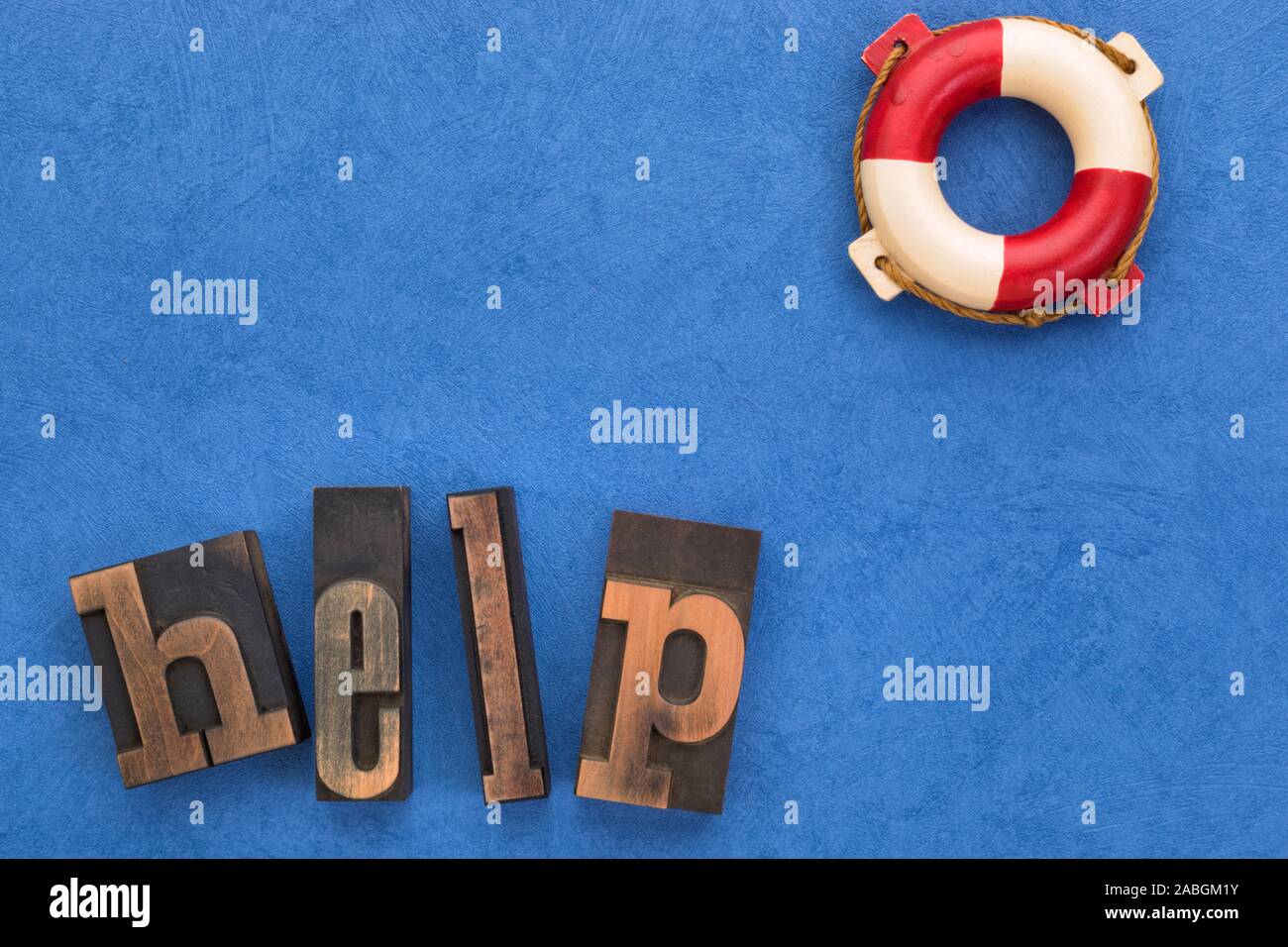 Concetto di supporto. Parola help set con vintage tipo di stampa in rilievo e la vita di boa testurizzato su sfondo blu con spazio di copia Foto Stock