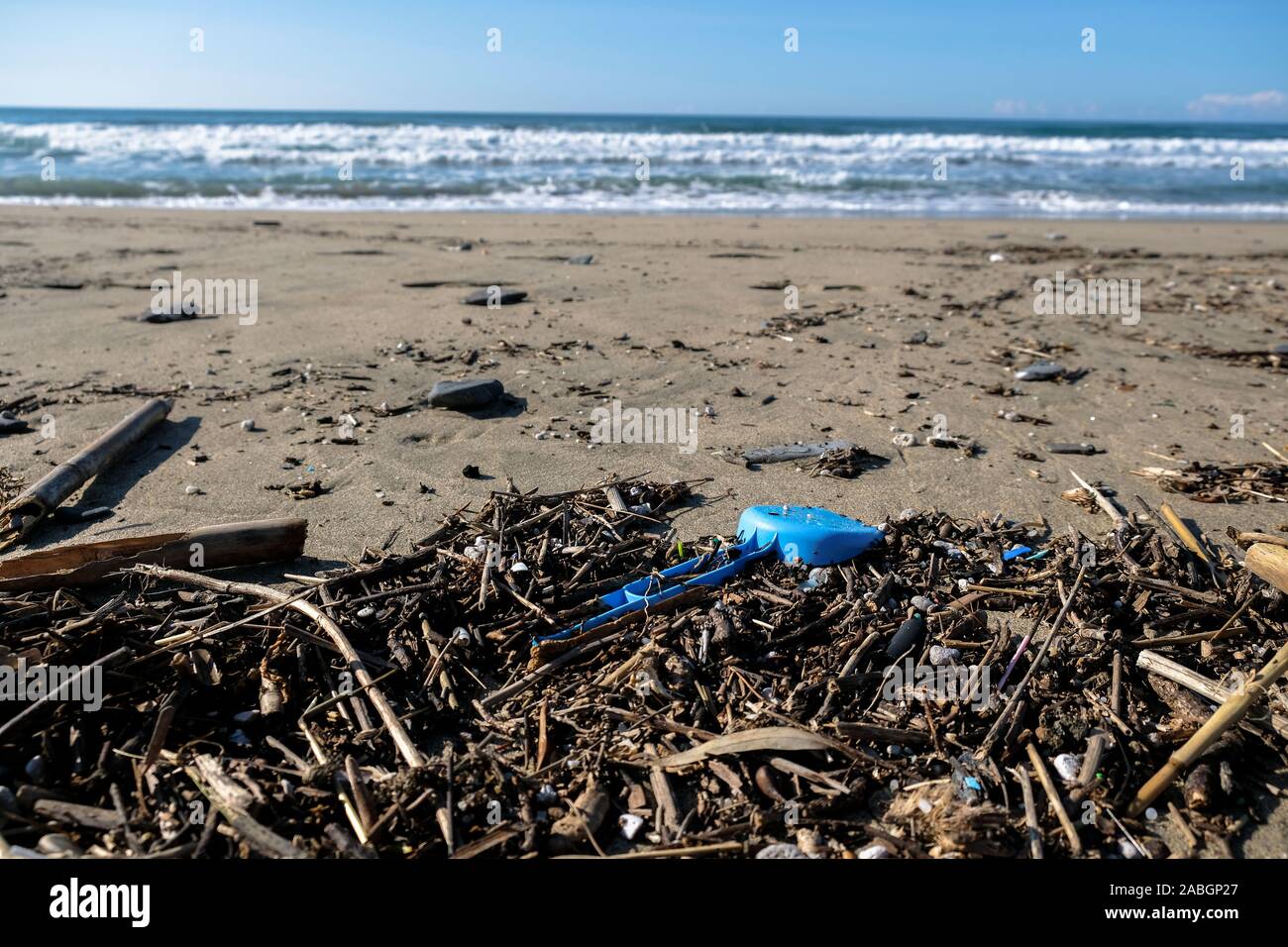 Inquinamento, plastica giocattolo per bambini sul mare invernale costa sulla sfocatura dello sfondo,il pianeta Foto Stock