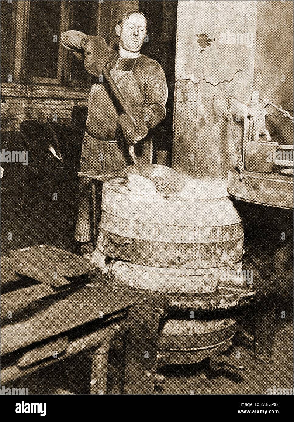 Una rara e insolita fotografia storica che mostra un dipendente della banca negli anni quaranta manualmente verso il basso di fusione le monete straniere presso gli Stati Uniti Ufficio di saggio per estrarre oro e altri metalli preziosi. Foto Stock