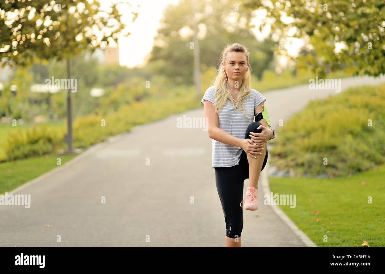 La donna è stretching prima di fare jogging nel parco - all'aperto per il fitness e il concetto di stile di vita Foto Stock