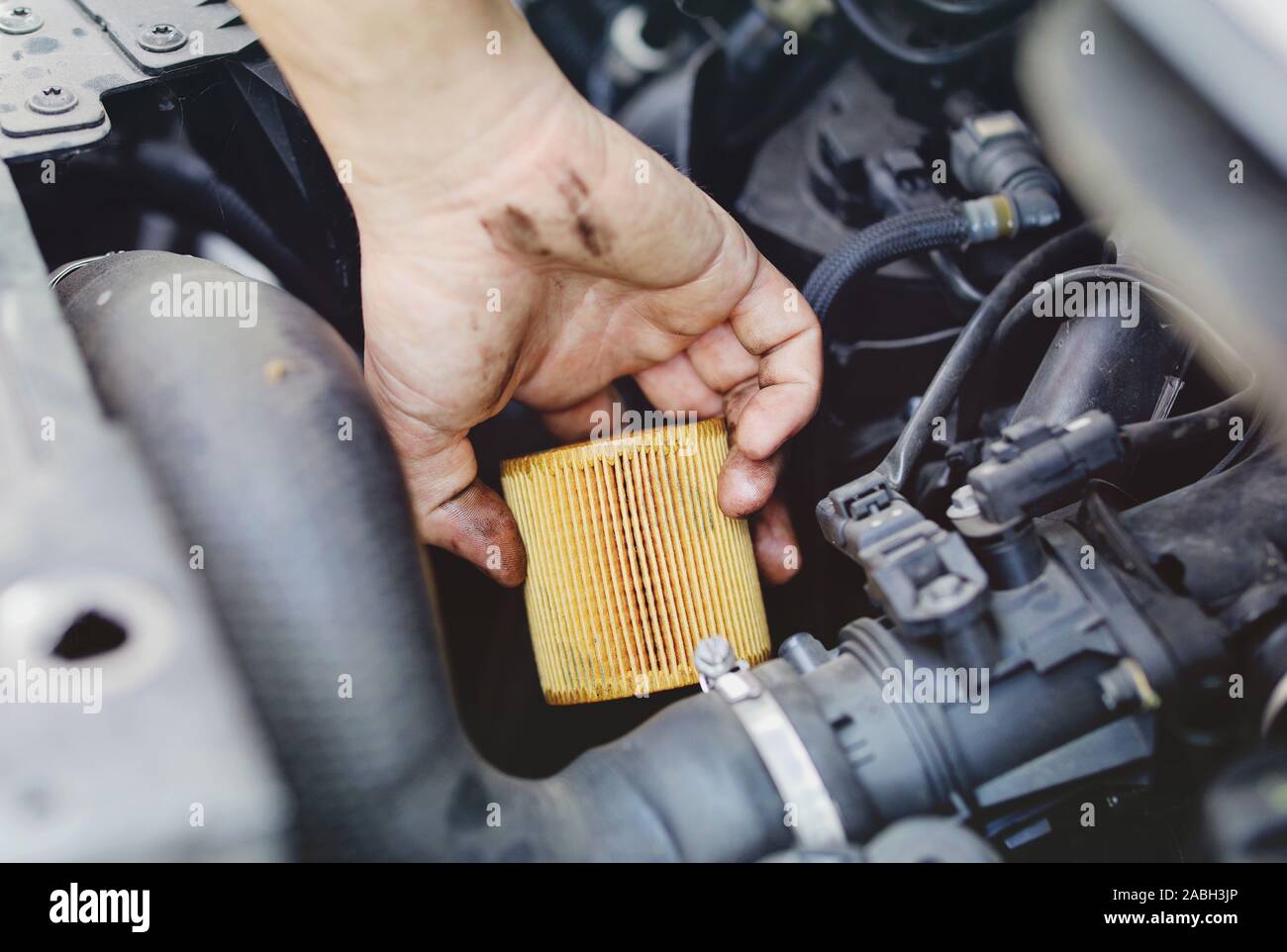 Chiudere la mano di un irriconoscibile meccanico facendo auto di servizio e manutenzione - filtro per olio e carburante modifica Foto Stock