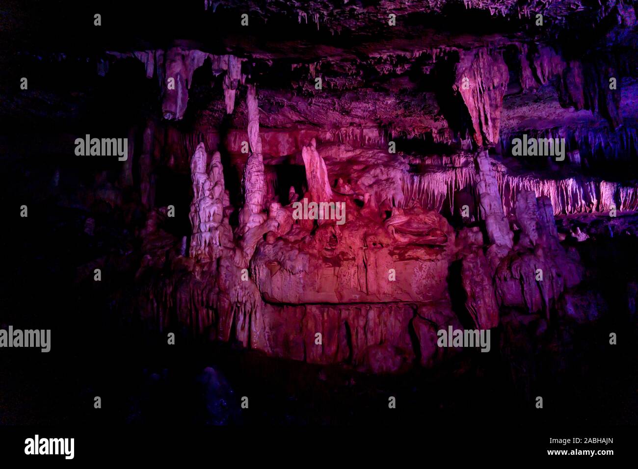 Illuminato con luce rossa grotta di stalattiti con sfondo Foto Stock