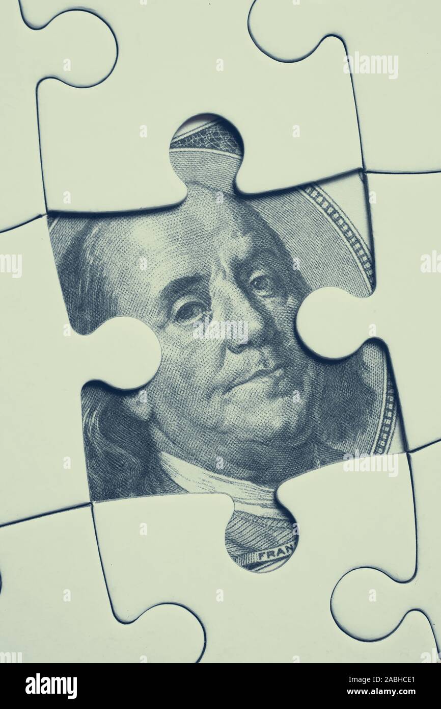 Immagine su 100 dollaro statunitense Bill immagine aperta sotto il bianco puzzle. Concetto di nascosto la finanza, contabilità in partita doppia,, stash di denaro. Verticale. Foto Stock