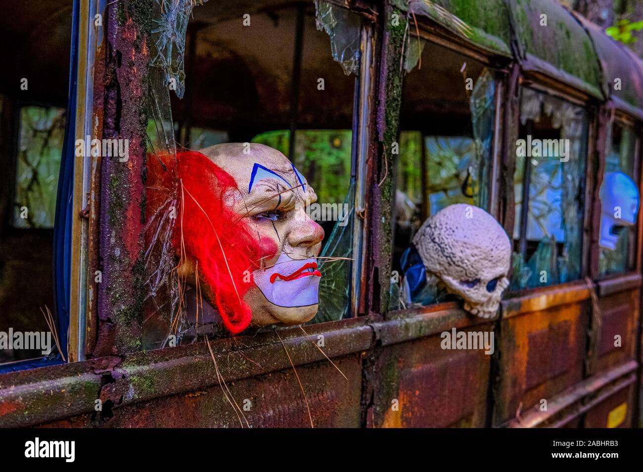 Spooky maschere su un arrugginito fuori la vecchia scuola bus Foto Stock