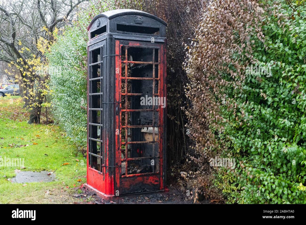 Anti il comportamento sociale - bruciata telefono rosso scatola nel South Yorkshire villaggio di Barnburgh, che era stato usato come un villaggio library Foto Stock