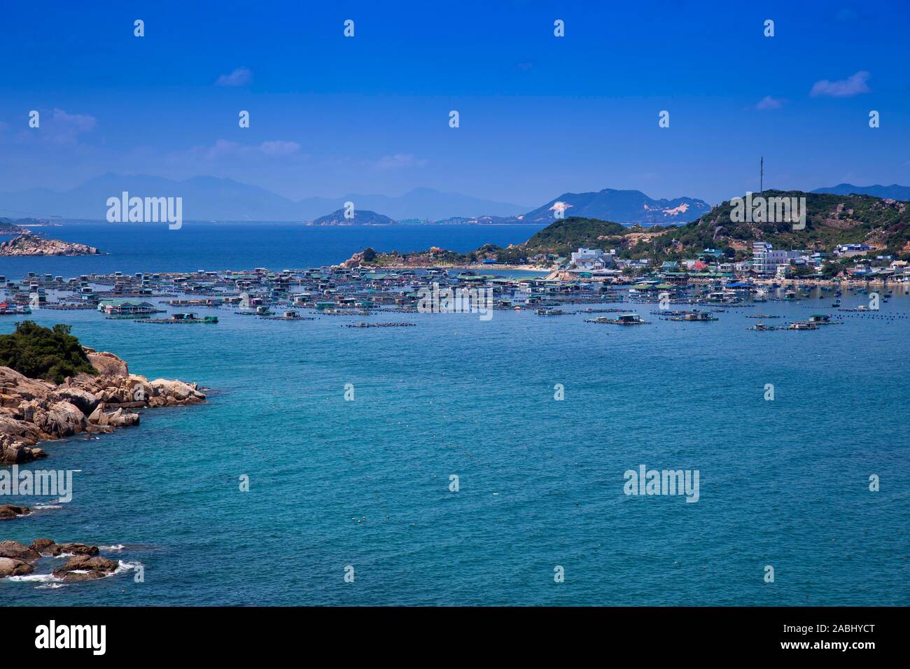 Rocky il paesaggio costiero con le case galleggianti nei pressi di Vinh Hy, sul Mare della Cina del Sud, Ninh Thuan, Vietnam Foto Stock