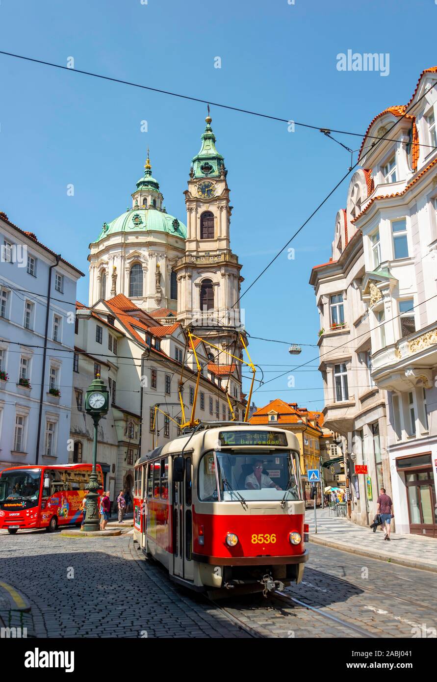 Red tram passa attraverso una strada, la chiesa di San Nicola, Lesser Town, Praga, Boemia, Repubblica Ceca Foto Stock