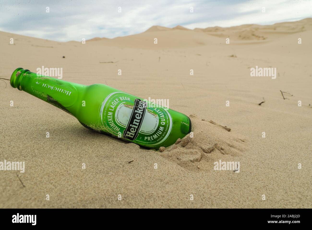 Bottiglia di vetro, Heineken birra Pilsener. verde bottiglia inquinamento e spazzatura per le dune di sabbia del deserto Samalayuca, Chihuahua in Messico. 52 km a sud di Foto Stock