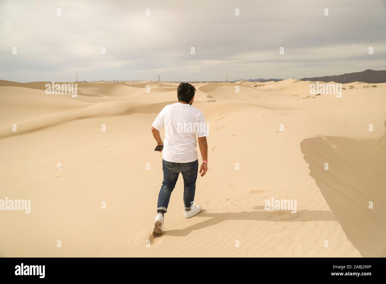 Un uomo cammina dune di sabbia del deserto Samalayuca, Chihuahua in Messico. 52 km a sud di Ciudad Juárez nel mezzo del deserto area conosciuta come il Médanos Foto Stock