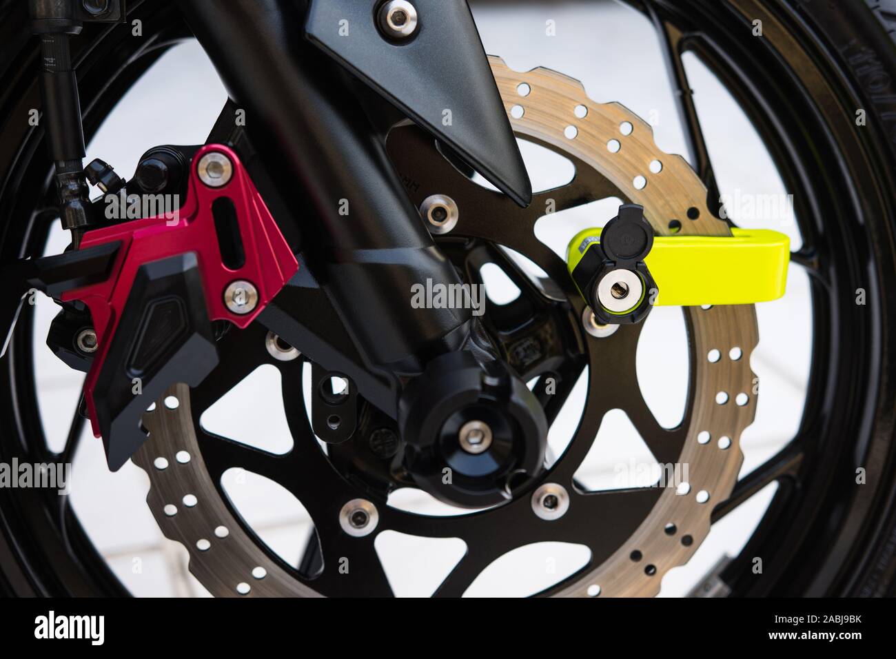 Primo piano del blocco del disco giallo sul freno a disco per motociclette. Foto Stock
