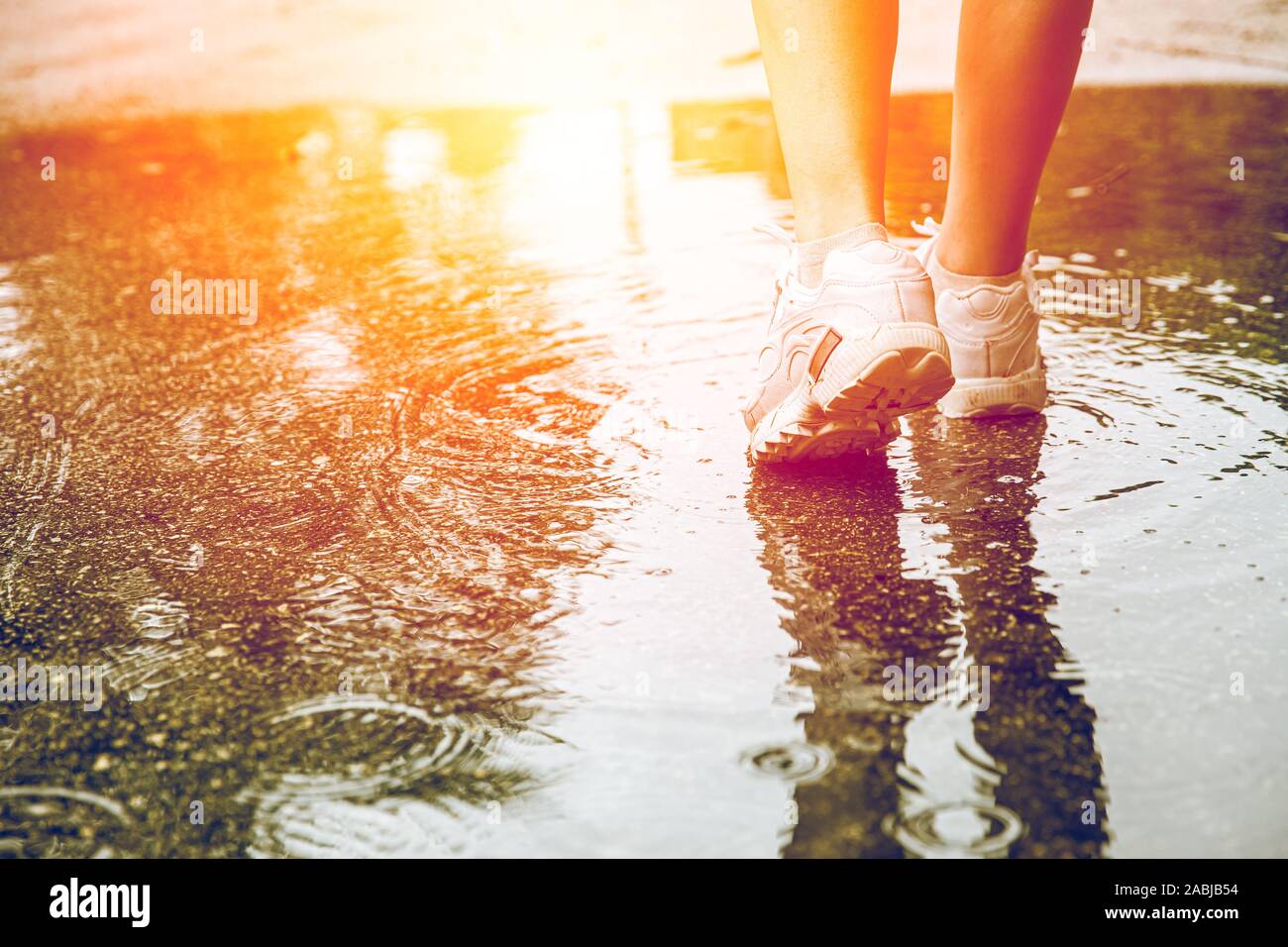 Closeup piedi in acqua a terra dopo la pioggia per scavalcare ostacoli nella vita alla prossima buona cosa forte senza alcun timore. Foto Stock