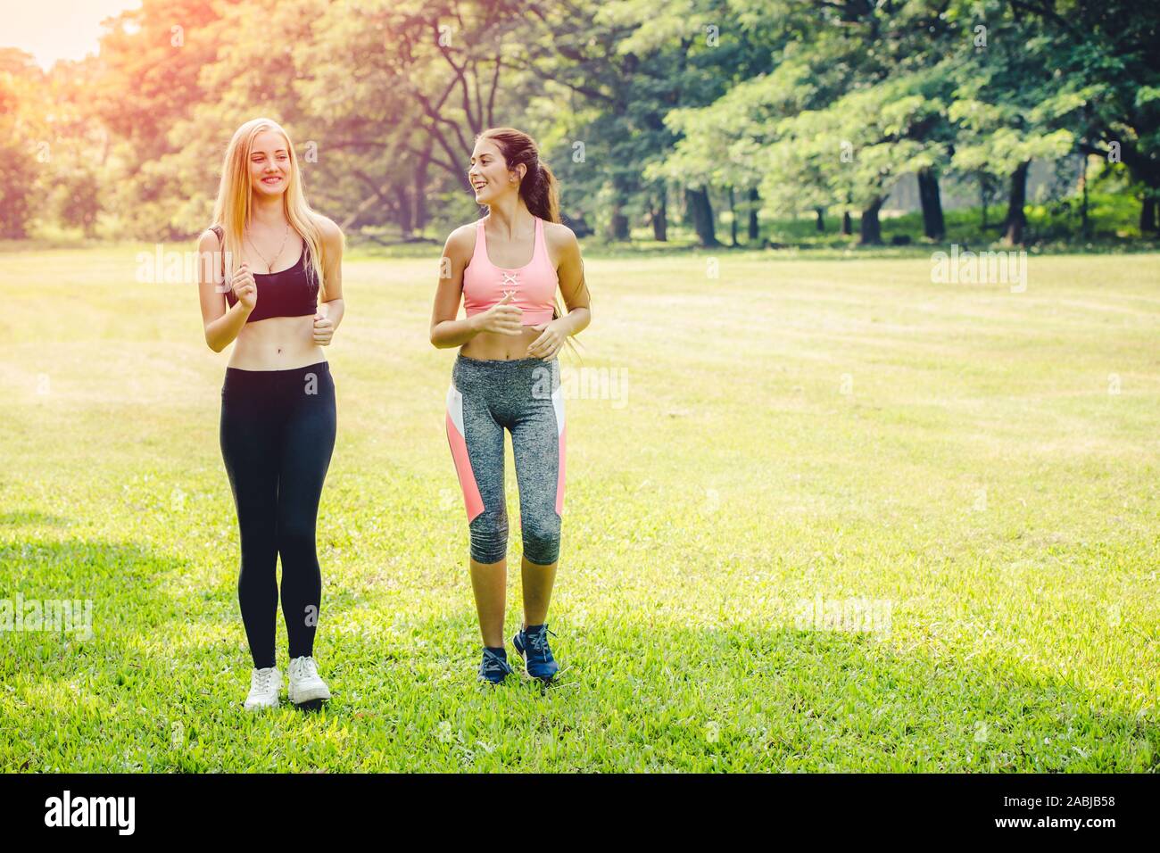 Due ragazze amico jogging insieme all'aperto parco verde. Foto Stock