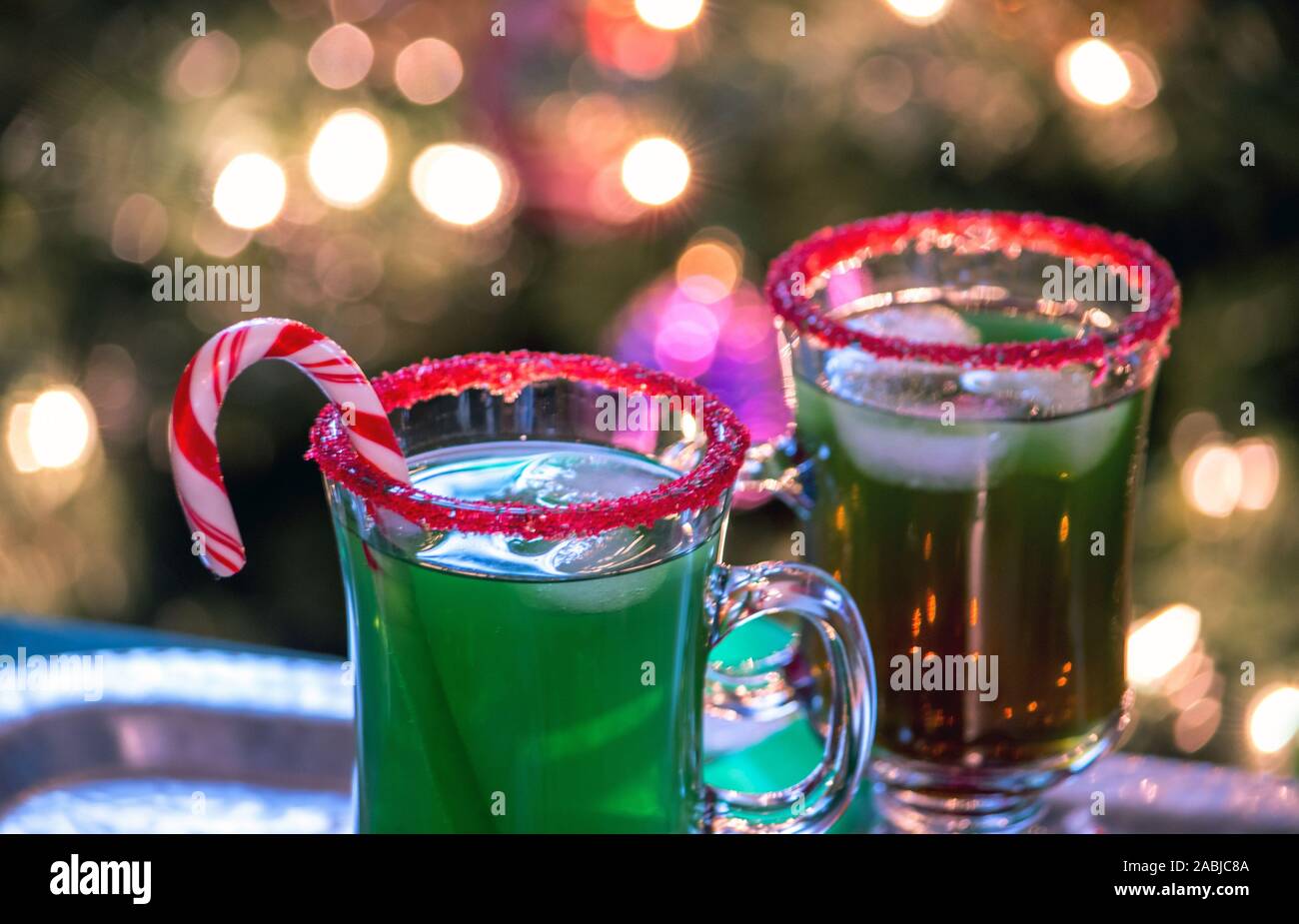 Colorata in verde sono bevande guarnita di un delizioso Christmas party. rosso cerchi di zucchero e un candy cane li rendono più festosa Foto Stock