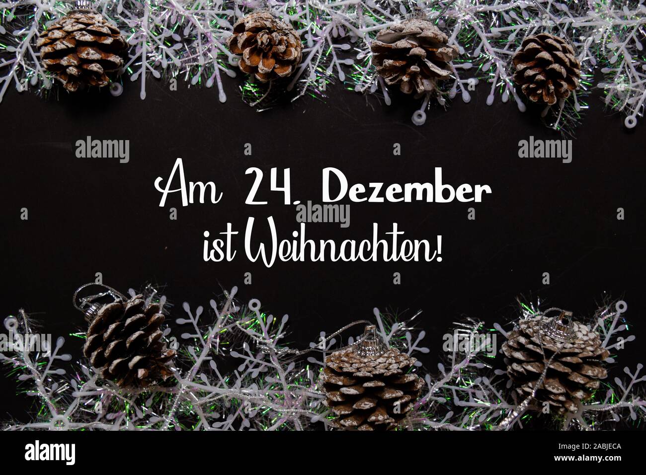 Am 24. Dezember Ist Weihnachten isolato di testo su sfondo nero. Ciò significa buon Natale. Telaio della decorazione di Natale. Foto Stock